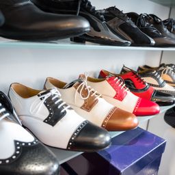Ein Regal mit mehreren Paar Schuhen in verschiedenen Farben und Stilen, einige in Kisten.