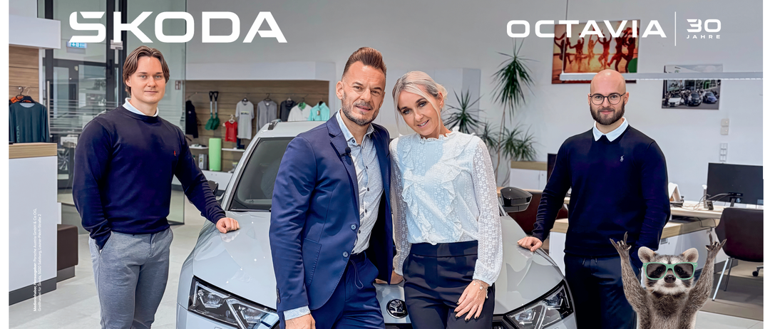 Drei Männer und eine Frau stehen neben einem Skoda Octavia und lächeln für ein Foto. Unter dem Auto steht ein Text zur Feier der 30-jährigen Geschichte des Skoda Octavia. Das Bild enthält auch Datum und Uhrzeit der Veranstaltung.