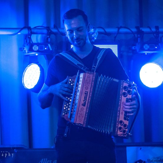 Bild enthält, Lighting, Adult, Male, Man, Person, Concert, Crowd, Musical Instrument, Face, Head