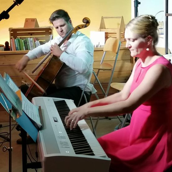 Ein Mann und eine Frau spielen gemeinsam Musik. Der Mann spielt Cello und die Frau Klavier.
