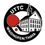 UTTC Waidhofen/Thaya-Logo. Ein schwarzes kreisförmiges Logo zeigt die Worte 'UTTC' in Weiß über einem roten Tischtennisschläger. Unter dem Schläger steht in Weiß 'Waidhofen/Thaya'. Der Hintergrund zeigt ein stilisiertes Gebäude mit vielen Fenstern und einem Turm.