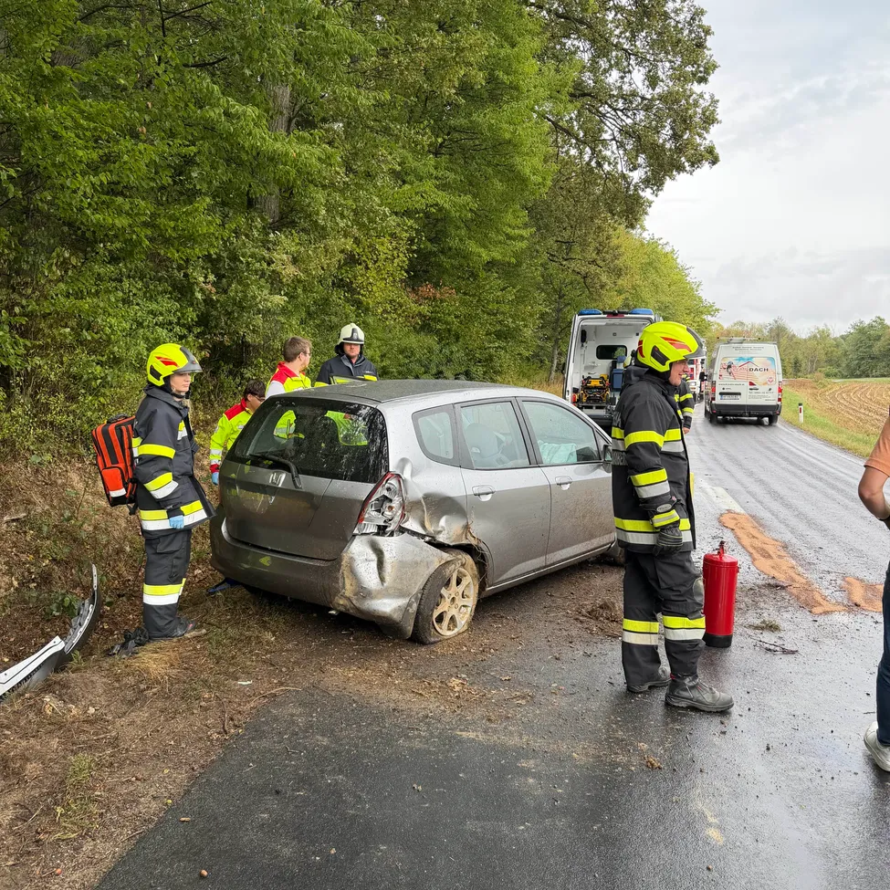 Rettungskräfte kümmern sich um ein beschädigtes Auto am Straßenrand.