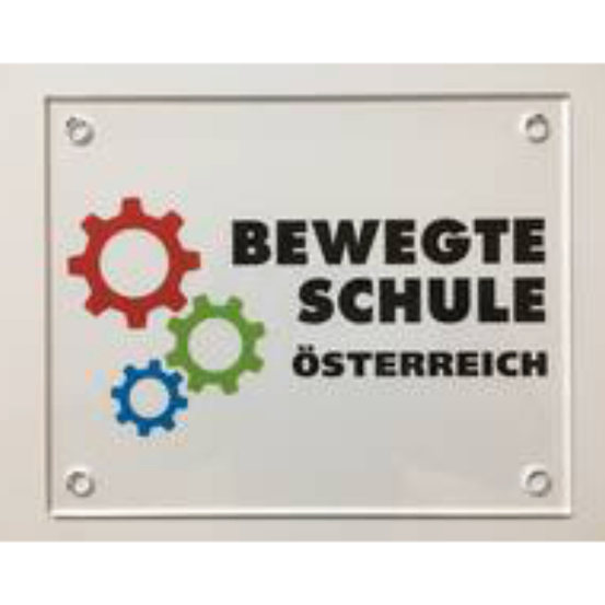 Ein Schild mit weißem Hintergrund zeigt drei Zahnräder in Rot, Grün und Blau mit dem Text 'Bewegte Schule Osterreich' darunter.