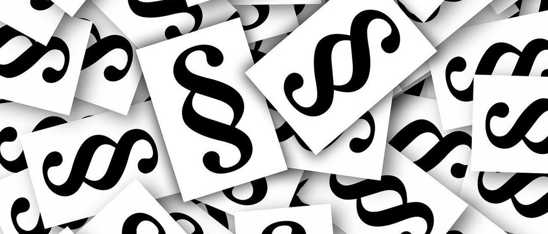 Ein Muster aus weißen Karten mit schwarzen Ampersand-Symbolen, die in einer Rasterform angeordnet sind.