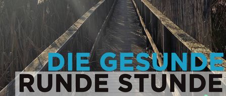 Ein Weg führt durch hohe Schilfrohre mit den Worten 'Die Gesunde Runde Stunde' in Blau auf weißem Hintergrund. Oben schweben zwei Figuren, eine hält ein Buch, gegen einen blauen Himmel.