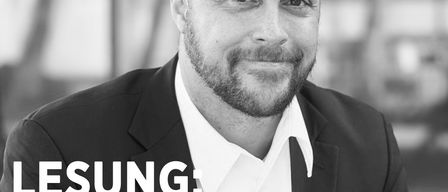 Ein Schwarz-Weiß-Porträt eines Mannes mit Bart und Schnurrbart in einem Anzug. Der Text lautet 'LESUNG: RENÉ ANOUR LIEST AUS SEINEM NEUEN DSCHUNGEL-THRILLER' und 'DIE GEJAGTE - SIE WEISS NICHT, WER SIE IST. ER SCHON'. Datum und Uhrzeit sind ebenfalls angezeigt.