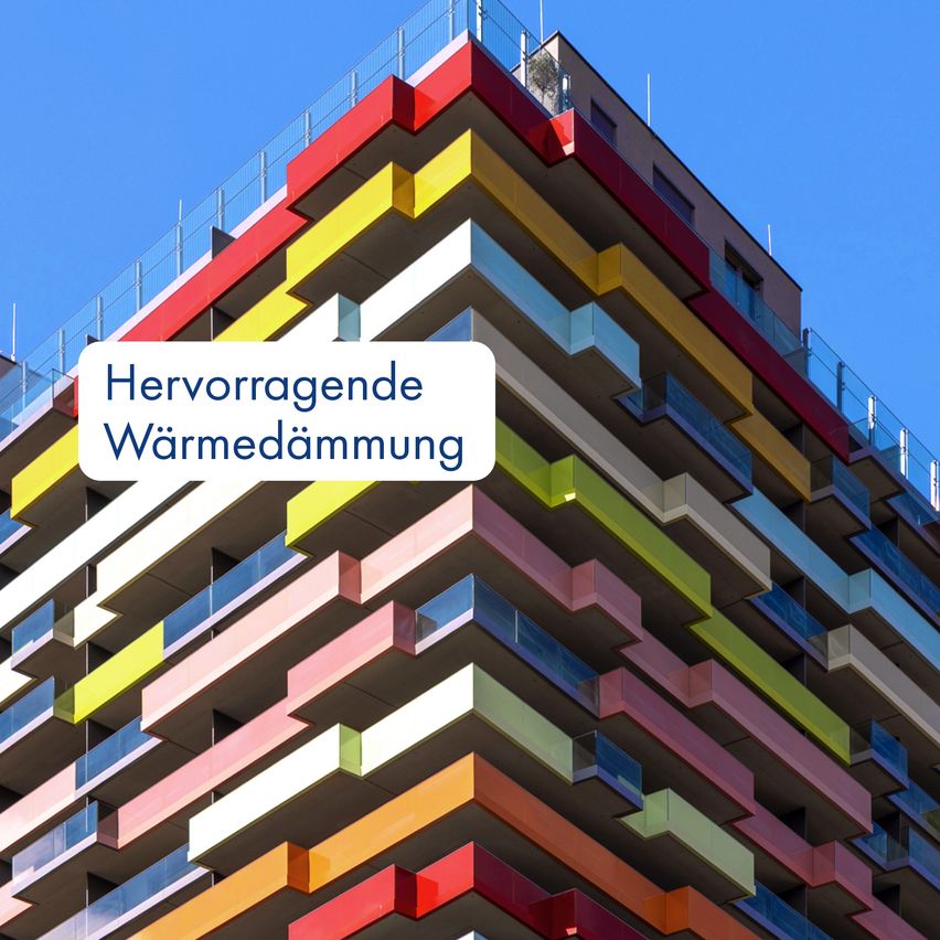 Ein Gebäude mit einer farbenfrohen Fassade und vielen Stockwerken. Die Worte 'Hervorragende Wärmedämmung' sind auf der Vorderseite angebracht.