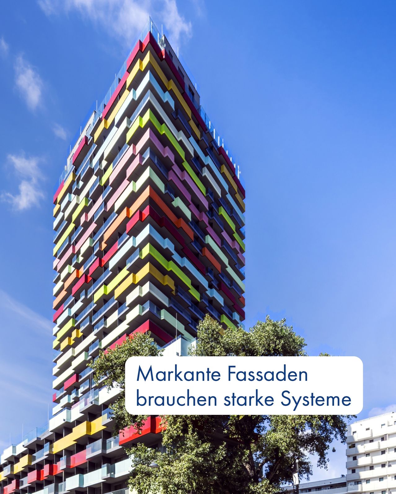 Ein farbenfroher Wolkenkratzer am blauen Himmel. Darunter steht, Markante Fassaden brauchen starke Systeme.