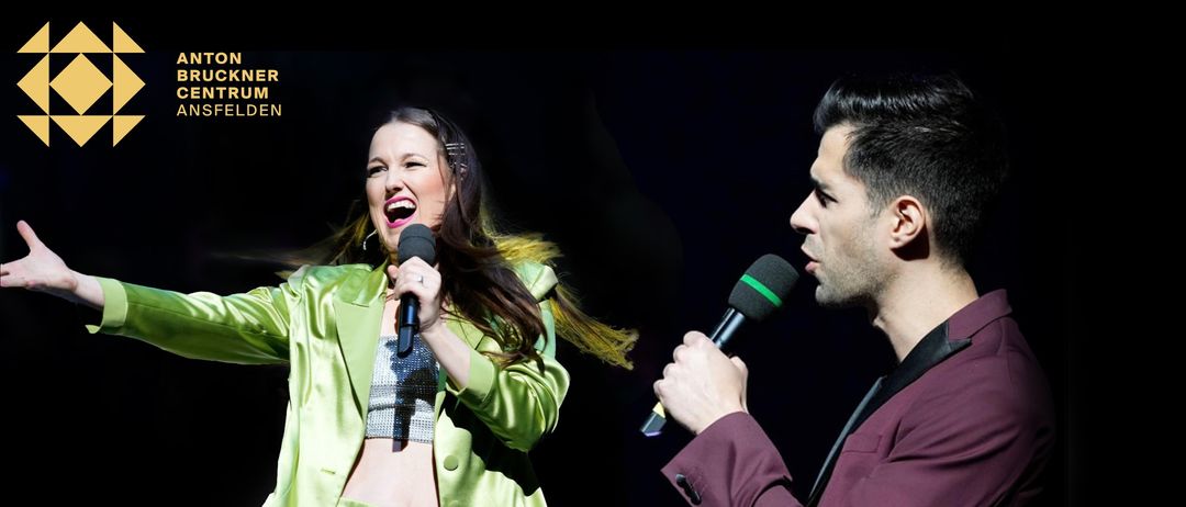 Eine Frau in einem leuchtend grünen Anzug singt in ein Mikrofon. Ein Mann in einem weinroten Anzug hält ein Mikrofon neben ihr.