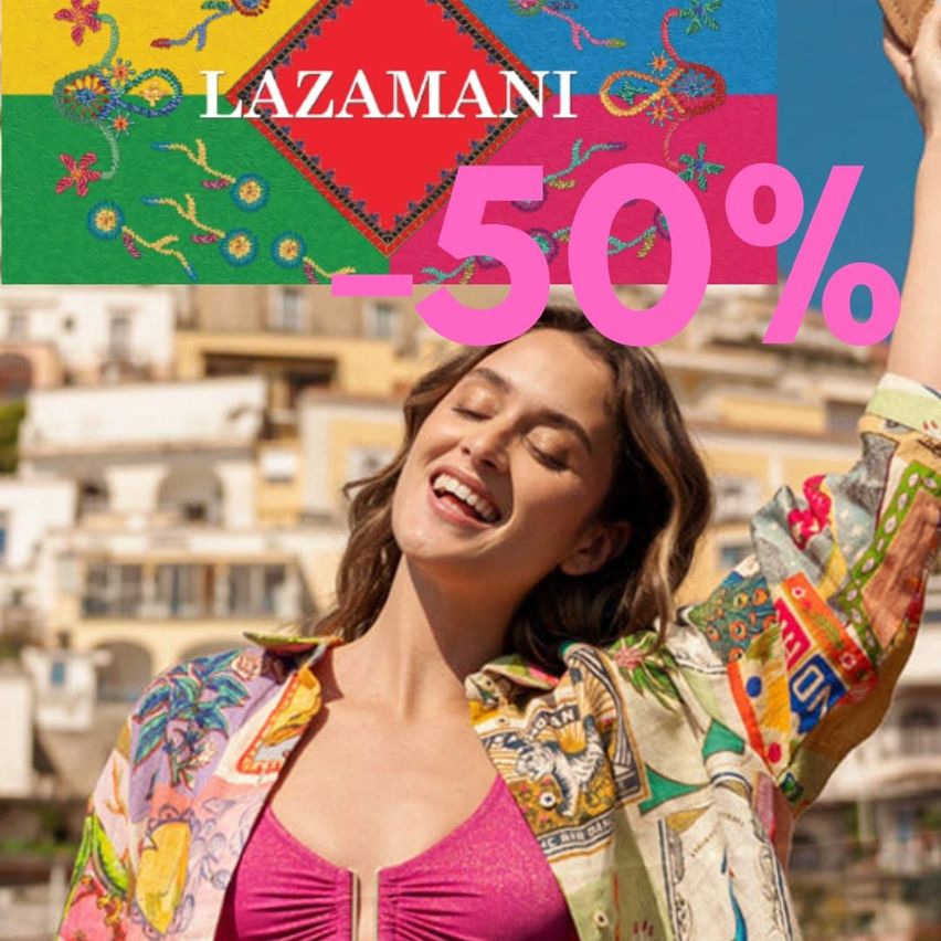 A smiling woman with a colorful jacket and pink top is raising her hands in front of a building with a 'LAZAMANI 50%' banner.