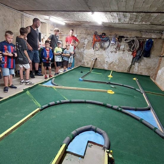 Bild enthält, Person, Fun, Golf, Mini Golf, Sport, Clothing, Shorts, Arrow, Weapon, Indoors