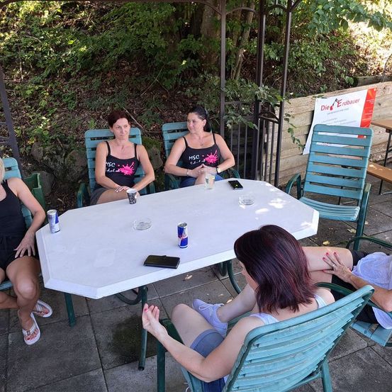 Bild enthält, People, Person, Furniture, Table, Tabletop, Adult, Female, Woman, Shorts, Face