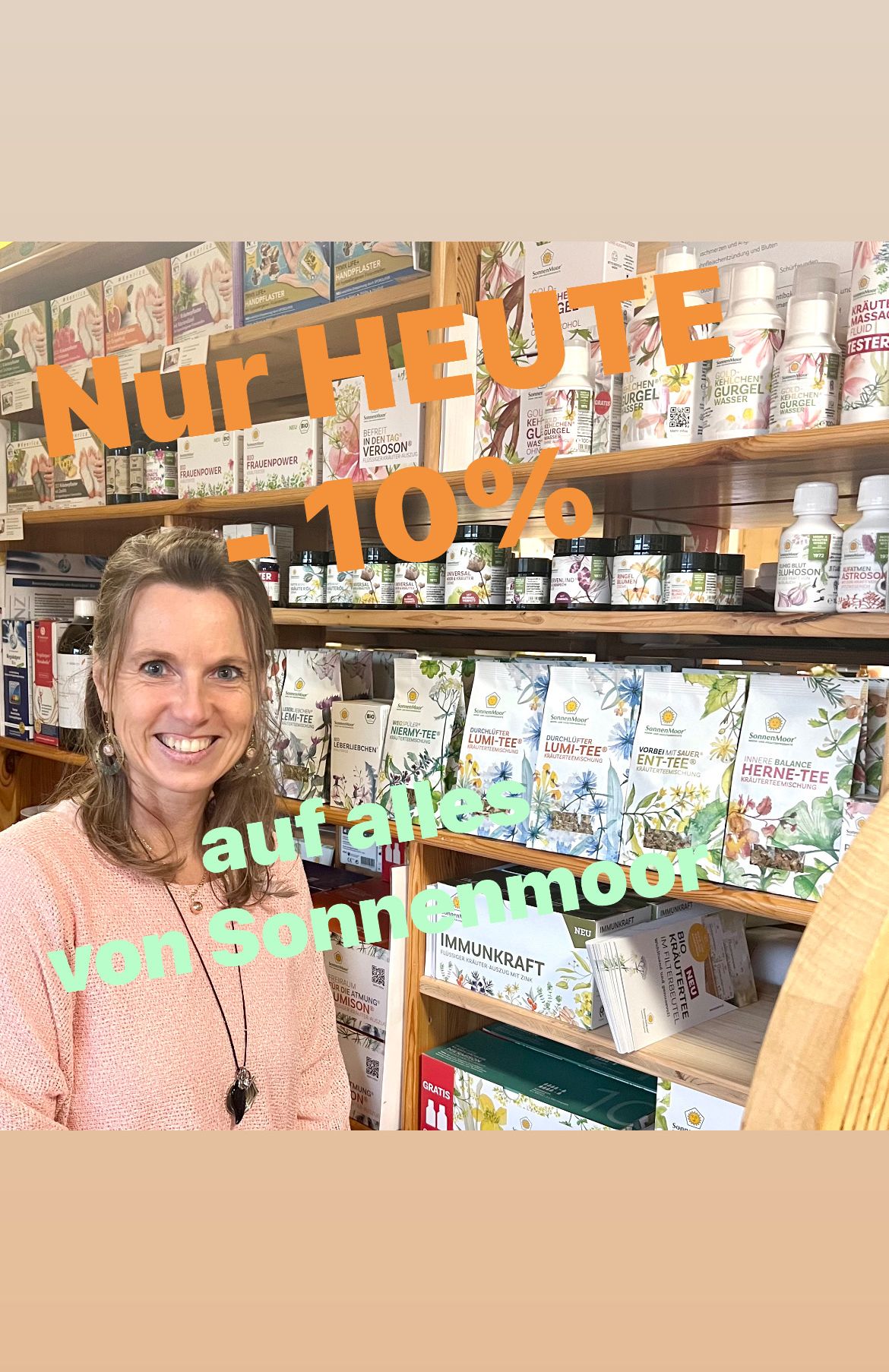 Eine Frau in einem rosa Pullover steht vor einem Regal voller verschiedener Kräuterprodukte. Die Regale sind mit Text in Orange und Grün beschriftet, und das oberste Regal hat die Aufschrift 'Nur Heute -10%'.