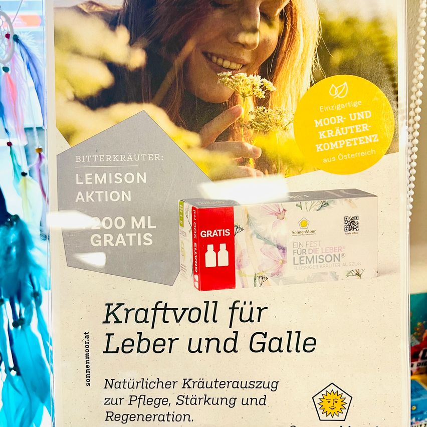 Ein Werbeposter zeigt eine lächelnde Frau, die eine Pflanze hält. Es bewirbt einen natürlichen Kräuterauszug zur Pflege, Stärkung und Regeneration von Leber und Galle. Das Produkt bietet 200 ml kostenlos an und hebt seine österreichische Herkunft hervor.