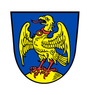Ein goldener Adler mit rotem Schnabel und rotem Kragen steht auf einem gelben Felsen auf blauem Hintergrund.