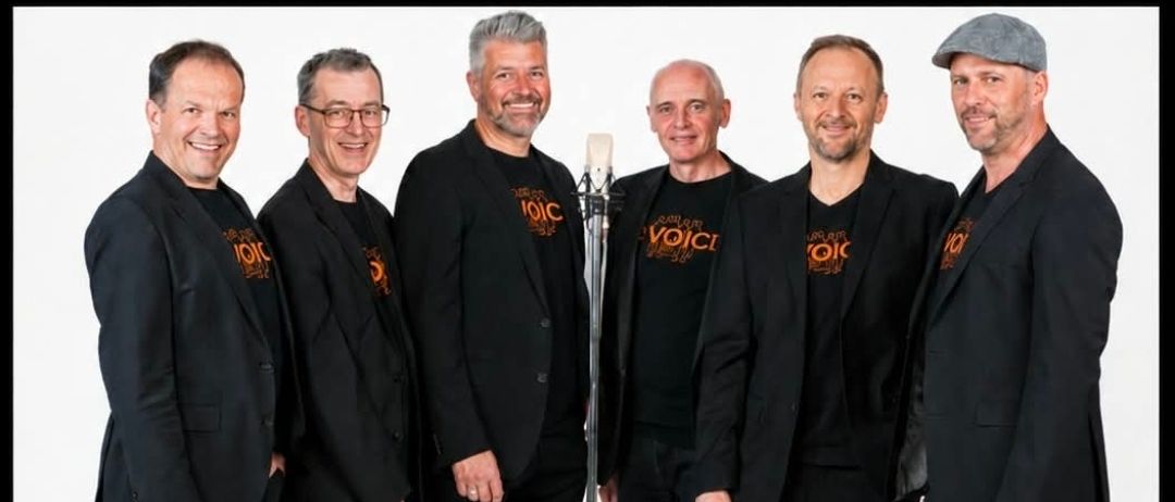 Plakat für ein Musikevent mit der Band The Voice, die 36 Jahre auf der Bühne feiert. Die Bandmitglieder sind in schwarzen Anzügen gekleidet und stehen vor einem Mikrofon. Das Event ist für den 16. Januar 2027 um 19:00 Uhr in Sinabelkirchen geplant.