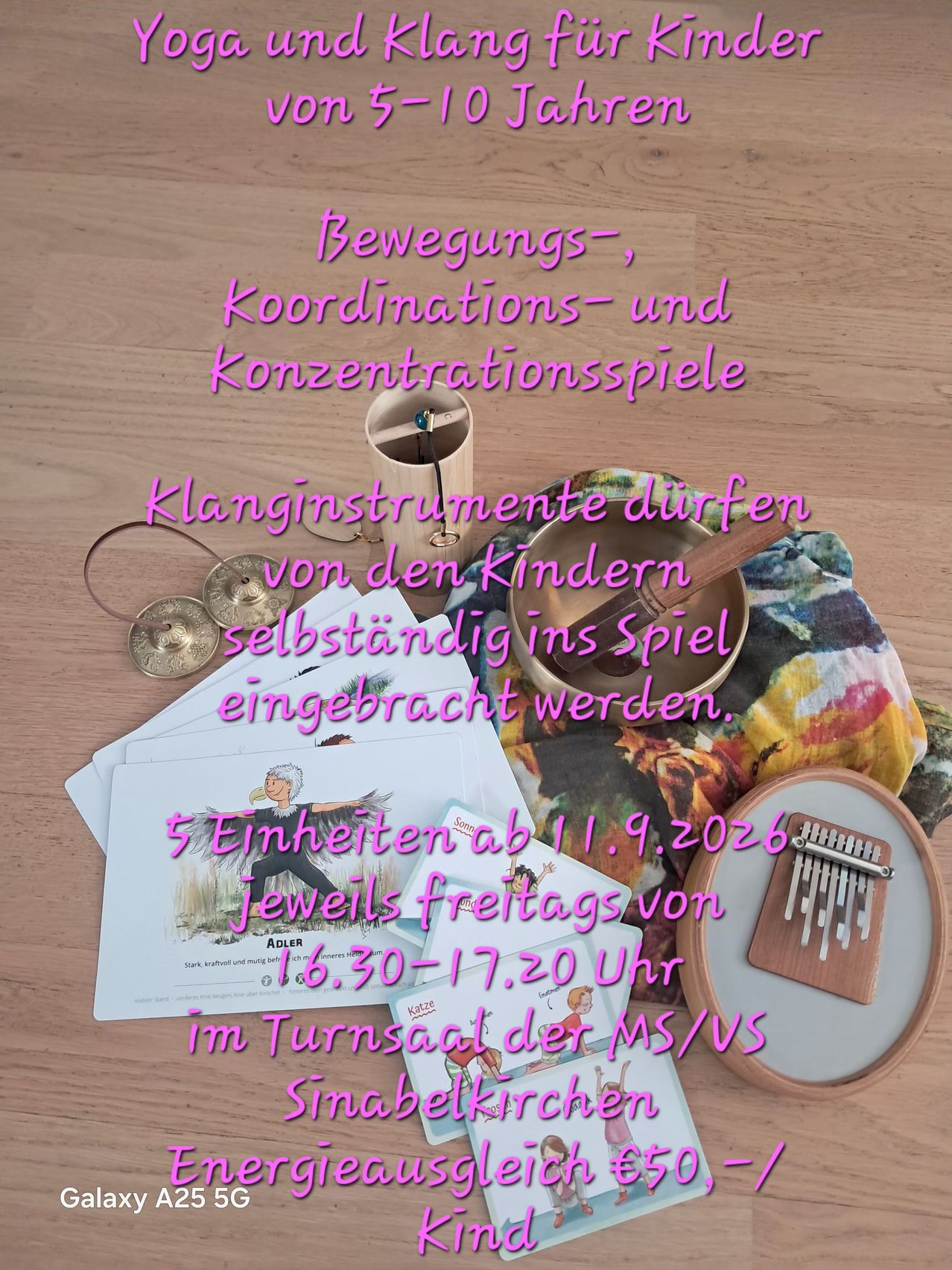 A wooden table displays various musical instruments and papers with text in German. The instruments include a gong, cymbals, and a xylophone. The papers have illustrations and text related to children's activities.