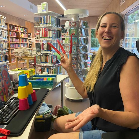 Bild enthält, Adult, Female, Person, Woman, Furniture, Book, Library, Publication, Computer Keyboard, Ring