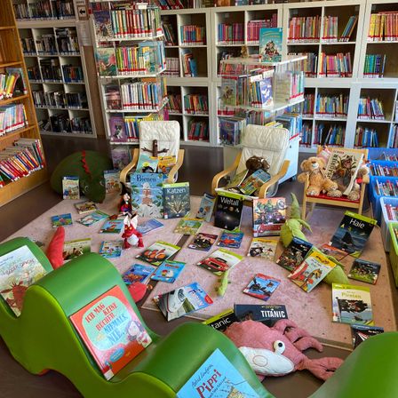 Bild enthält, Book, Indoors, Library, Publication, Furniture, Bookcase, Person, Toy, Chair
