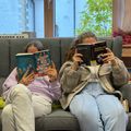 Bild enthält, Book, Publication, Library, Furniture, Person, Glove, Adult, Female, Woman, Shoe
