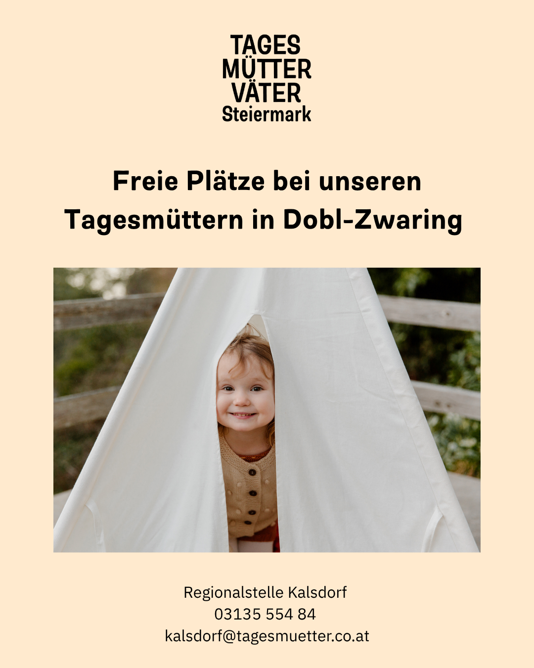 Ein lächelndes Kind, das aus einem weißen Zelt herausschaut, mit einem verschwommenen Hintergrund aus Zaun und Grün.