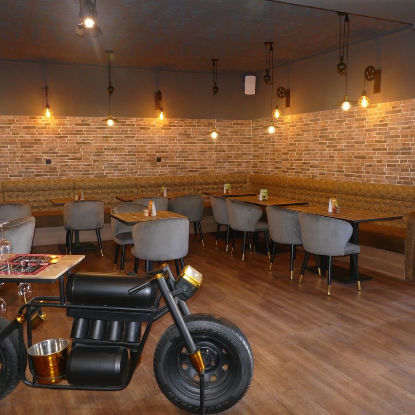 Bild enthält, Indoors, Interior Design, Wood, Chair, Wheel, Motorcycle, Floor, Restaurant, Building, Lighting