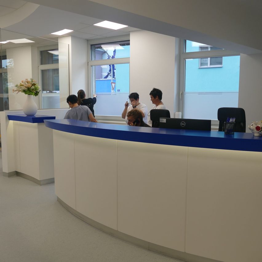 Bild enthält, Reception, Furniture, Table, Person, Desk, Building, Reception Desk, Indoors, Face, Chair