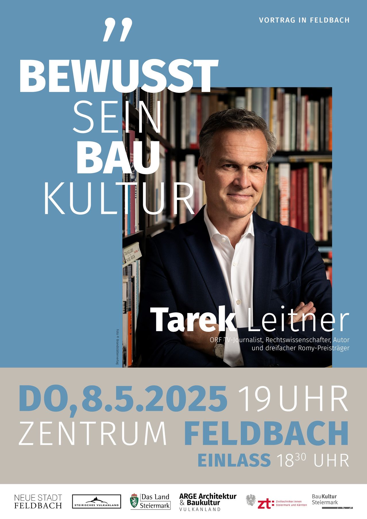 Plakat für eine Veranstaltung mit Tarek Leitner, der vor einem Bücherregal steht. Der Plakattext lautet 'Bewusst Sein Bau Kultur' und 'Tarek Leitner, ORF-TV-Journalist, Rechtswissenschaftler, Autor und dreifacher Romy-Preisträger.'