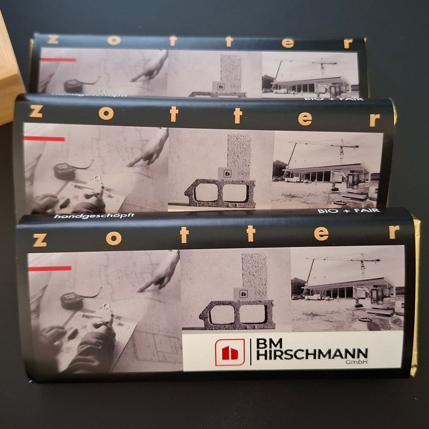 Three boxes of Zooter, a product by BM Hirschmann GmbH, stacked on top of each other. The packaging features a collage of construction site images and a hand holding a tool.