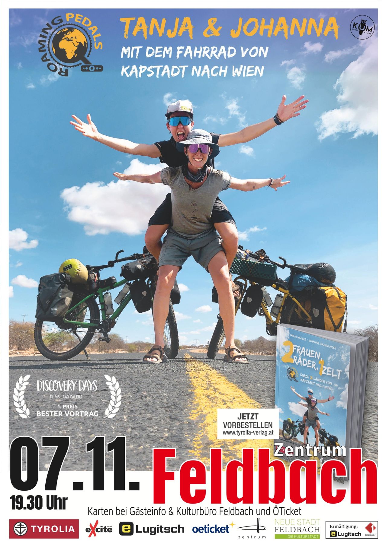 Zwei Radfahrer stehen auf einer Straße mit ihren Fahrrädern, einer trägt den anderen auf seinen Schultern. Sie tragen Mützen und Sonnenbrillen, und Taschen sind an ihren Fahrrädern befestigt. Ein Buch wird auf der rechten Seite angezeigt.