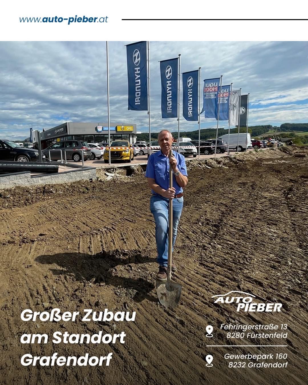 A man stands in a construction site holding a shovel, with a dealership in the background. Banners for various car brands are visible, and cars are parked nearby. The image includes text indicating a larger expansion at the location.