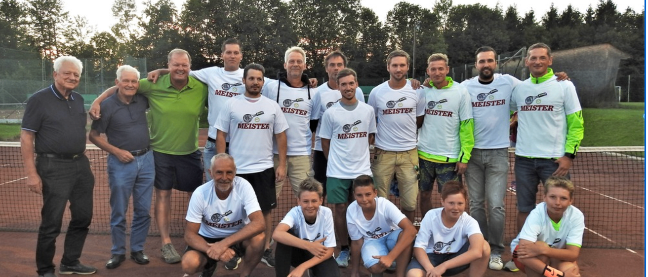 Eine Gruppe von Menschen, die Meister-Shirts tragen, posiert für ein Foto auf einem Tennisplatz mit Bäumen im Hintergrund.