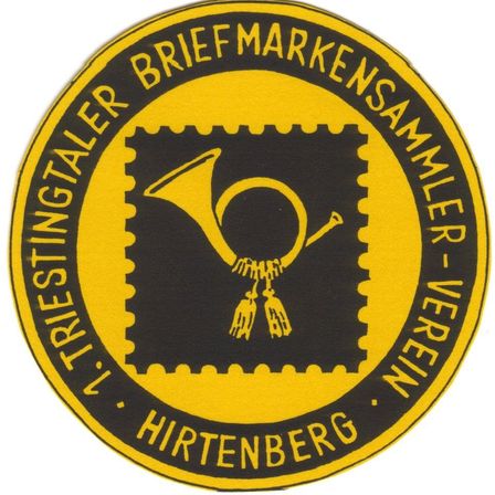 Ein kreisförmiges Emblem zeigt ein Trompetendesign, umgeben von den Worten 'V. Trienter Briefmarkensammler-Verein Hirtenberg'. Das Emblem ist gelb und schwarz.