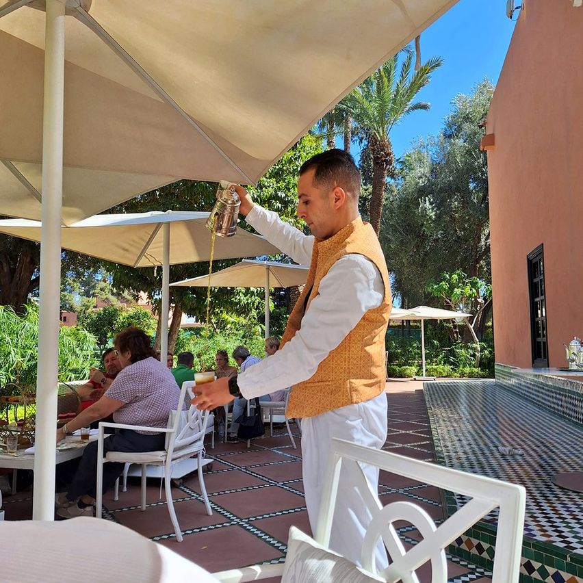 Bild enthält, Person, Waiter, Adult, Male, Man, Bag, Handbag, Chair, Furniture, Dining Table