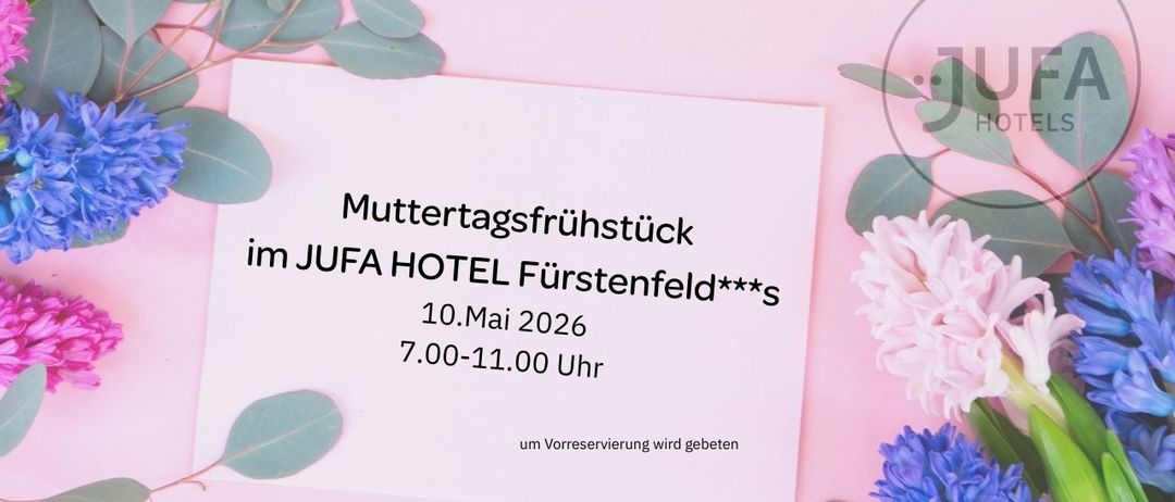 Eine weiße Karte auf einem rosa Hintergrund mit grünen Blättern. Es steht 'Muttertagsfruhstuck im JUFA HOTEL Furstenfeld***s', '10. Mai 2026', '7.00-11.00 Uhr' und 'um Vorreservierung wird gegeben'.