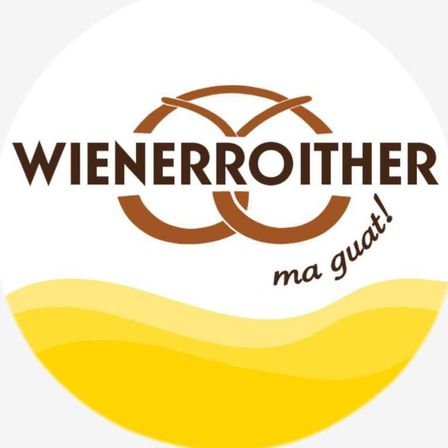 Das Logo von Wienerroither zeigt den Firmennamen in fettem braunem Schriftzug, mit zwei ineinander verschlungenen Ringen darunter. Der Slogan 'ma guat!' ist in einer stilisierten Schrift darunter geschrieben. Der Hintergrund ist ein Farbverlauf von Gelb und Weiß.