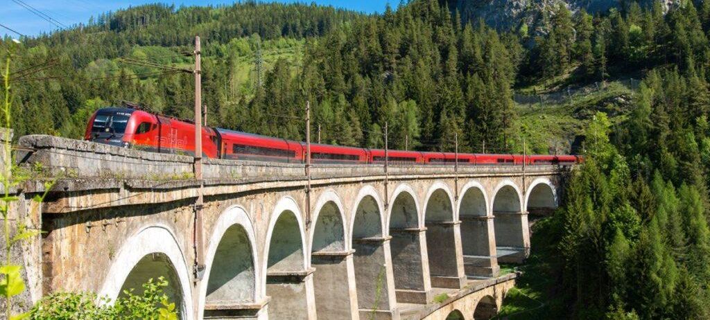 Bild enthält, Architecture, Bridge, Building, Viaduct, Train, Transportation, Vehicle, Plant, Vegetation, Arch