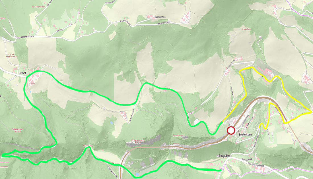 Eine Karte zeigt ein bergiges Gebiet mit mehreren grünen und gelben Wegen, einem roten Kreis, der einen Ort namens Breitenstein hervorhebt, und verschiedenen Geländemerkmalen wie Hügeln und Tälern.