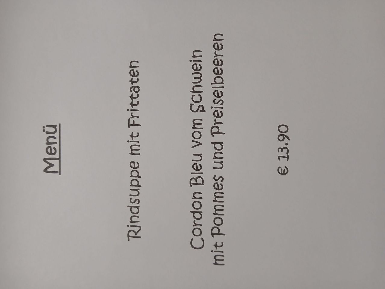 A menu featuring beef soup with fried potatoes, Cordon Bleu with Schwein, and pommes frites with Preiselbeeren priced at 13.90 Euros.