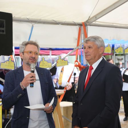 Bild enthält, Microphone, Speaker, Crowd, Person, Tie, Handbag, Bracelet, Glasses, Adult, Man