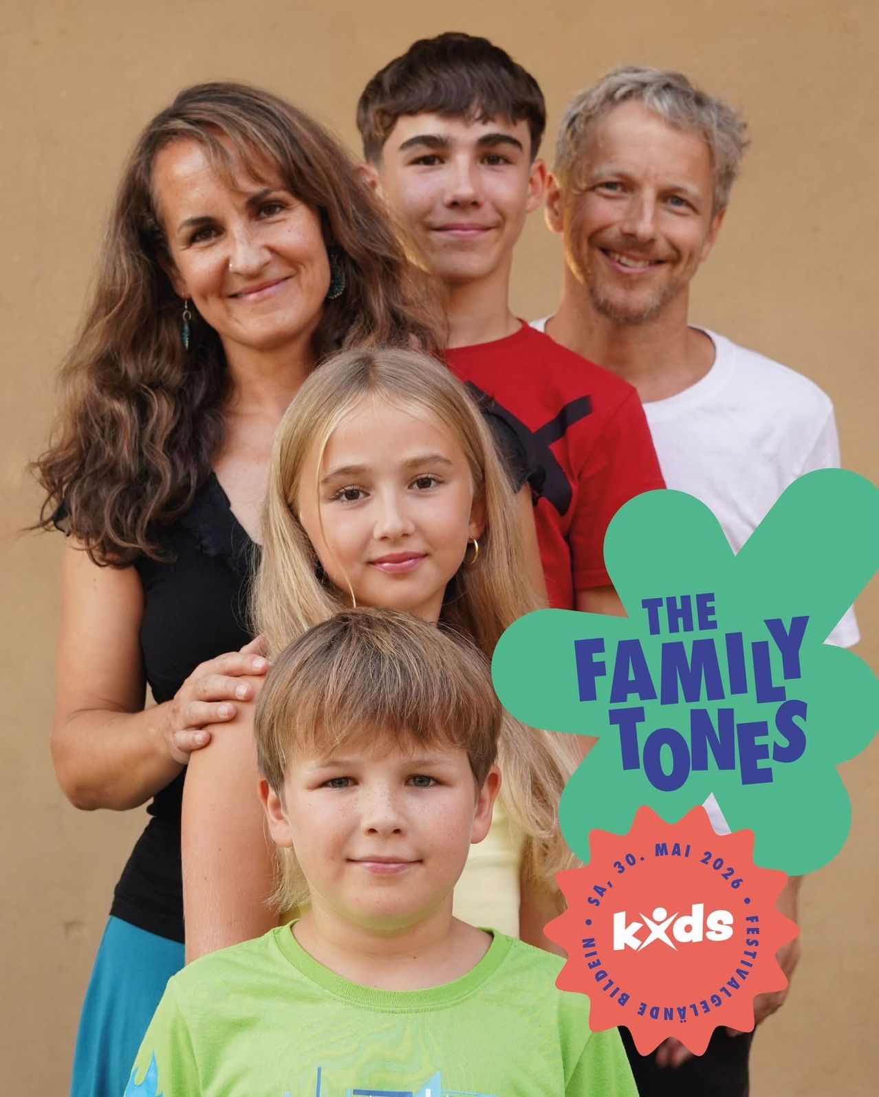 A smiling family of four, consisting of two adults and two children, posing for a photo with the words 'The Family Tones' in a green clover shape.