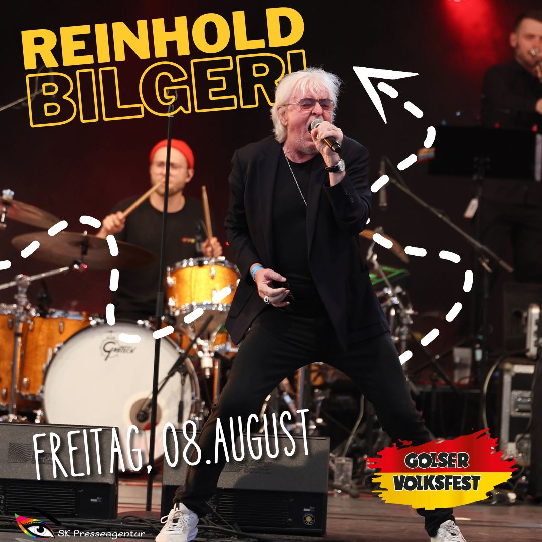Ein Mann mit weißen Haaren singt auf der Bühne, mit Trommeln und Becken hinter ihm. Ein Plakat mit dem Text 'Reinhold Bilgeri' und 'Freitag, 08. August'. Der Mann trägt einen schwarzen Anzug und weiße Turnschuhe. Ein Wasserzeichen mit dem Text 'Sk Presseagentur' befindet sich unten links.