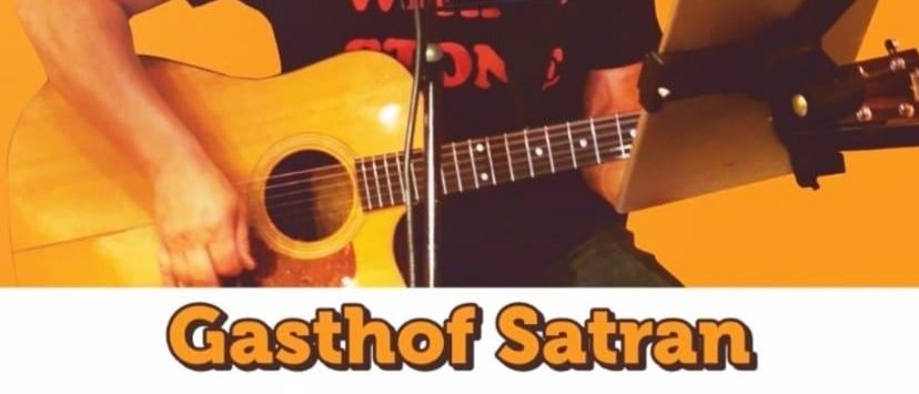 Ein Mann spielt Gitarre und singt in ein Mikrofon vor einem gelben Hintergrund. Der Text 'Austropop und mehr' ist oben angezeigt.