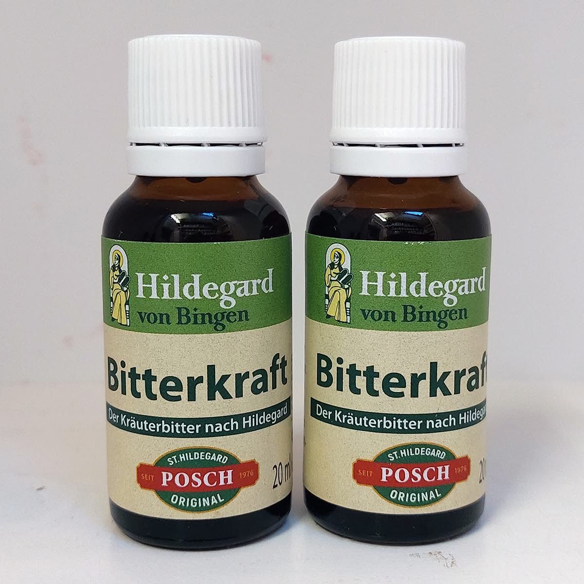 Zwei Flaschen Hildegard von Bingen Bitterkraft, ein Kräuterbitter, stehen auf einer weißen Oberfläche. Die braunen Flaschen haben grüne Etiketten mit dem Markennamen 'Hildegard von Bingen' und dem Produktnamen 'Bitterkraft'. Jede Flasche ist mit einem weißen Deckel verschlossen.