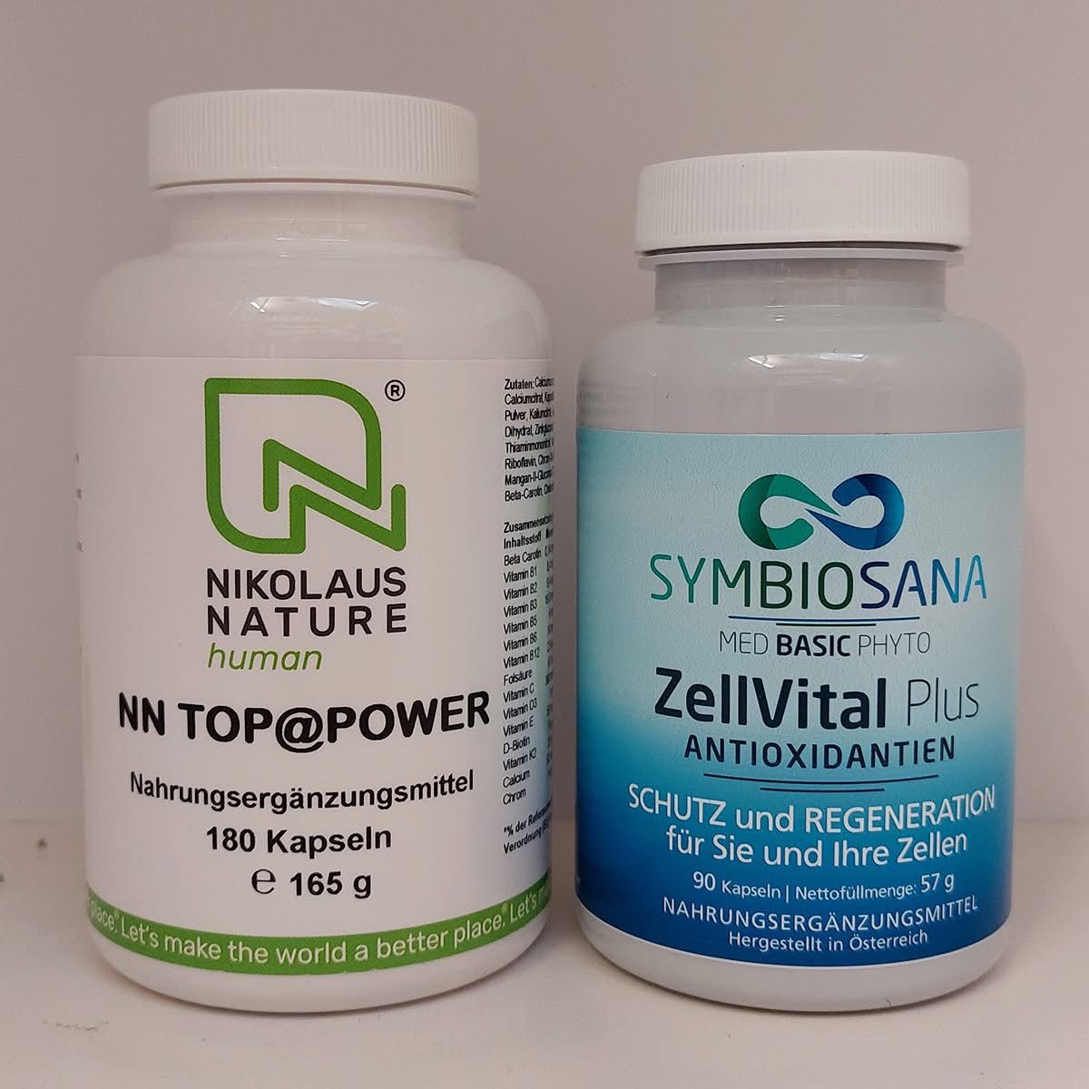 Zwei Flaschen Nahrungsergänzungsmittel, eine beschriftet mit 'Nikolaus Nature Human' und die andere mit 'SymbioSana Med Basic Phyto ZellVital Plus Antioxidantien.' Beide sind weiß mit grünen Akzenten und gefüllt mit Kapseln.