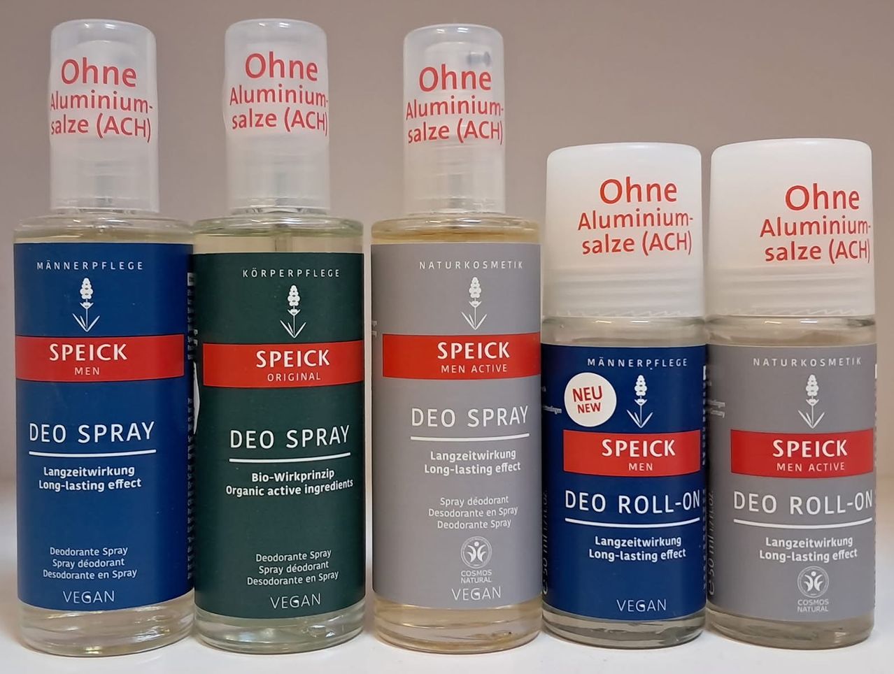 Five deodorant bottles in different colors and labels, all featuring the brand 'Speick' and the phrase 'Ohne Aluminiumsalze (ACH)'. Three are sprays, one is a roll-on, and one is a solid. All are vegan and organic.