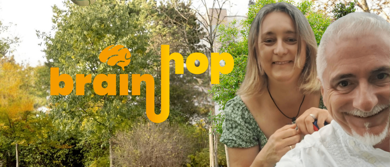 Eine Frau, die ein Baby im Freien hält, mit dem Brainhop-Logo im Hintergrund.