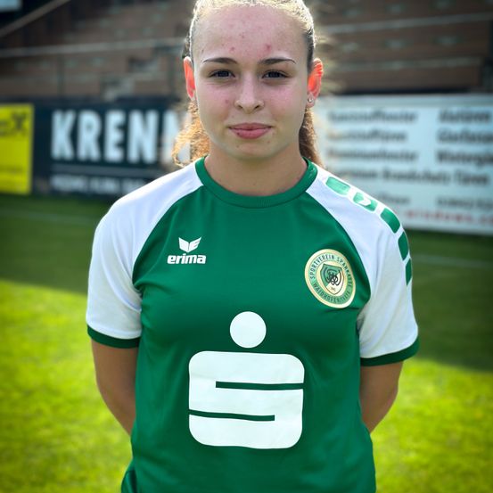 Eine Fußballspielerin steht auf einem Fußballfeld und trägt ein grün-weißes Trikot mit Logo und der Nummer 9 auf der Vorderseite.