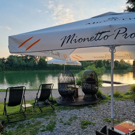 Bild enthält, Nature, Outdoors, Scenery, Chair, Grass, Plant, Person, Lakefront, Canopy, Water
