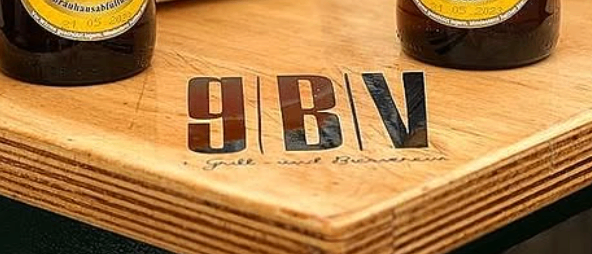 Zwei Flaschen Augustiner Bier stehen auf einem Holztisch mit einem Korb und einem Lebensmittelbehälter im Hintergrund.